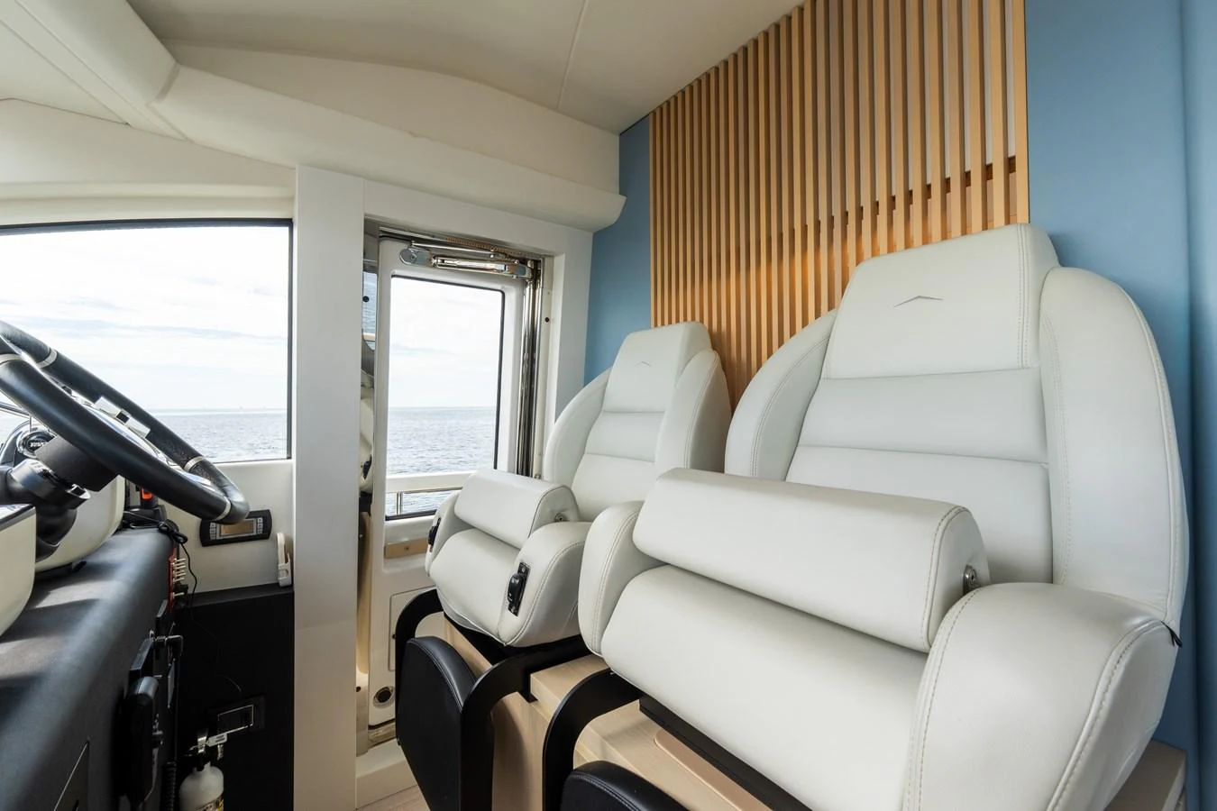 The helm area features luxurious white leather seating with a view of the sea. aboard GONE PHISHING Yacht for Sale