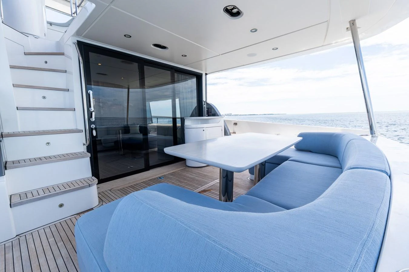 The aft deck features a comfortable seating area with a dining table, perfect for enjoying meals with a view of the sea. aboard GONE PHISHING Yacht for Sale