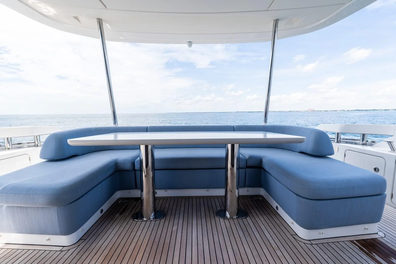 The aft deck features a spacious seating area with a sleek table, perfect for outdoor dining and relaxation. aboard GONE PHISHING Yacht for Sale