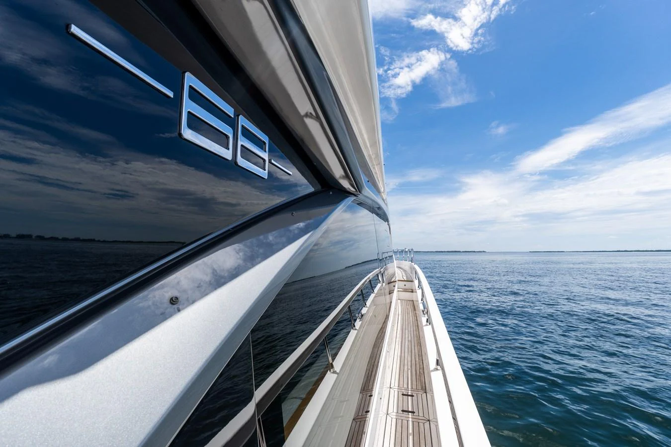 A sleek yacht cruises on calm waters under a bright blue sky. aboard GONE PHISHING Yacht for Sale