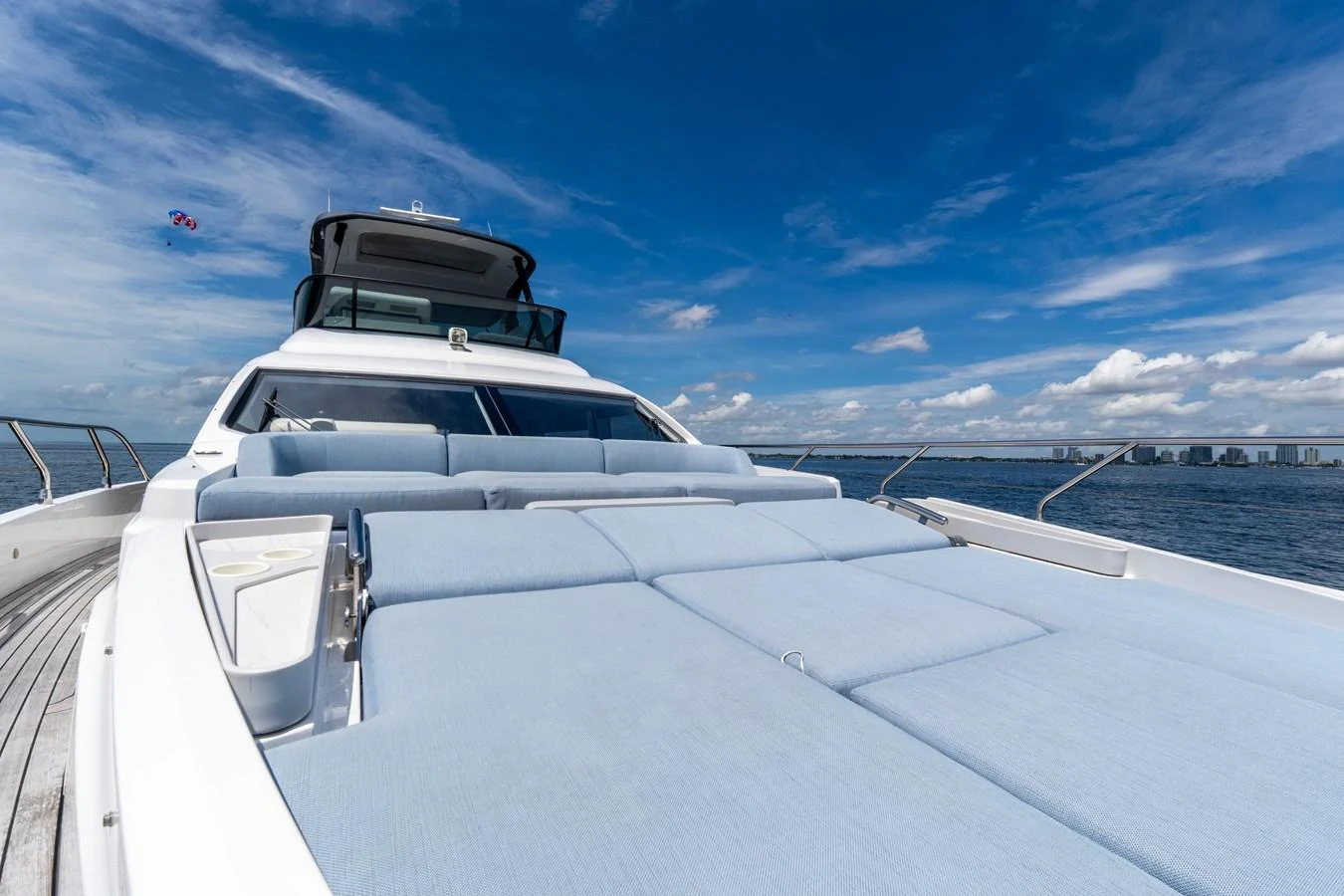 The yacht's foredeck features a spacious sunbathing area with plush cushions under a clear blue sky. aboard GONE PHISHING Yacht for Sale