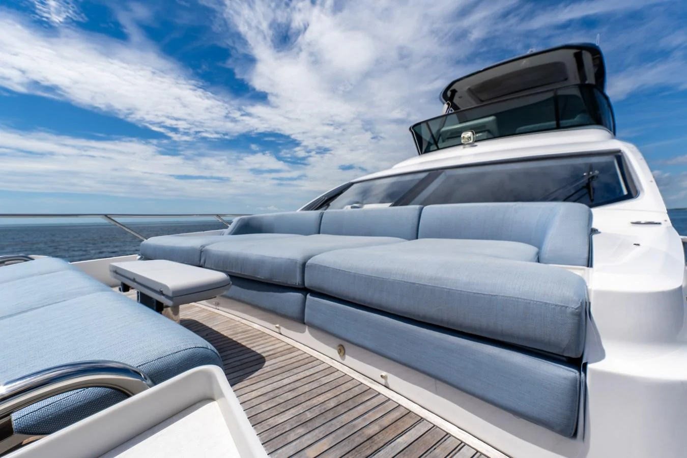 The yacht's exterior features a spacious and comfortable lounging area with plush seating under a bright blue sky. aboard GONE PHISHING Yacht for Sale