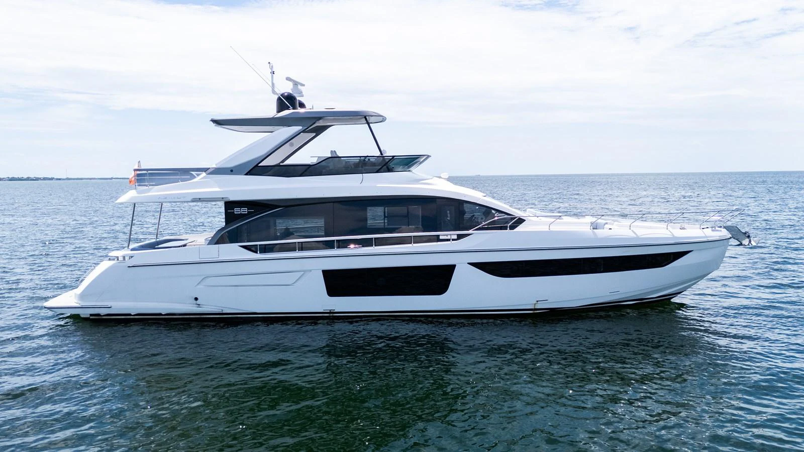 A sleek and modern yacht cruising on calm waters under a clear sky. aboard GONE PHISHING Yacht for Sale