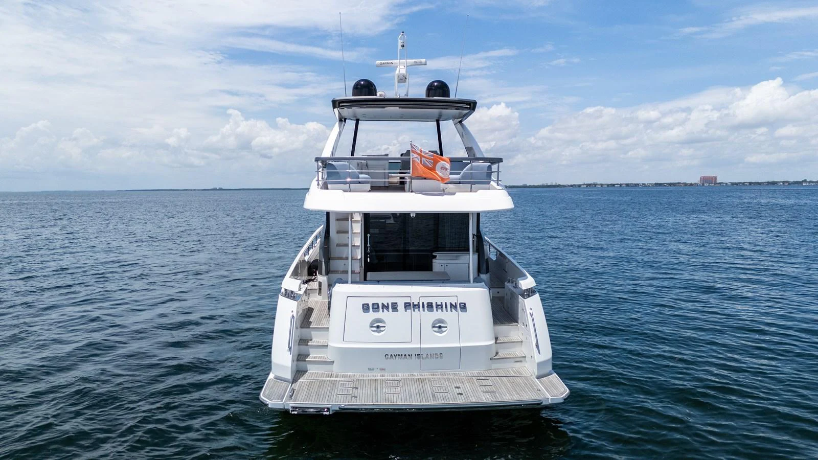 The yacht's aft deck is showcased against a serene ocean backdrop. aboard GONE PHISHING Yacht for Sale