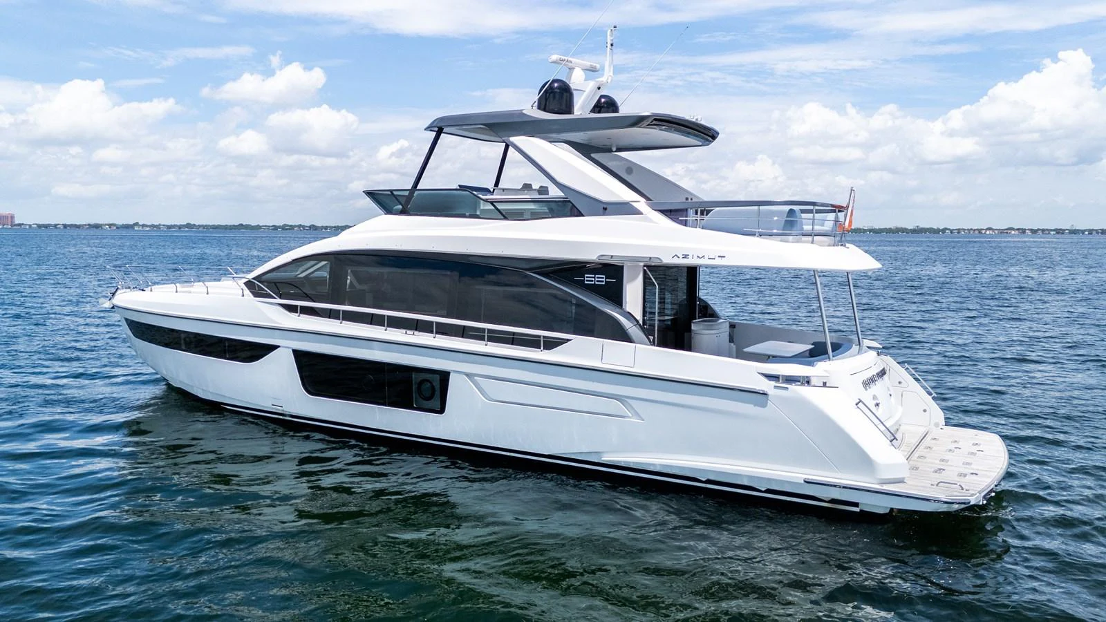 A sleek, modern yacht glides gracefully on calm waters under a partly cloudy sky. aboard GONE PHISHING Yacht for Sale