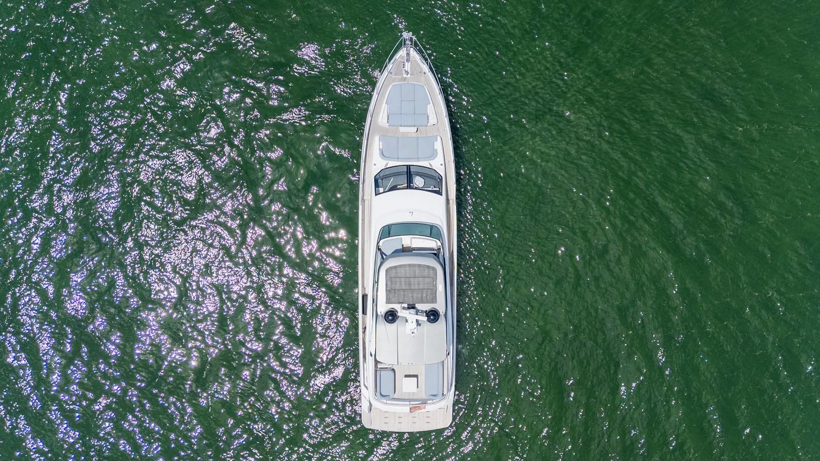 An aerial view of a sleek yacht cruising through green waters. aboard GONE PHISHING Yacht for Sale