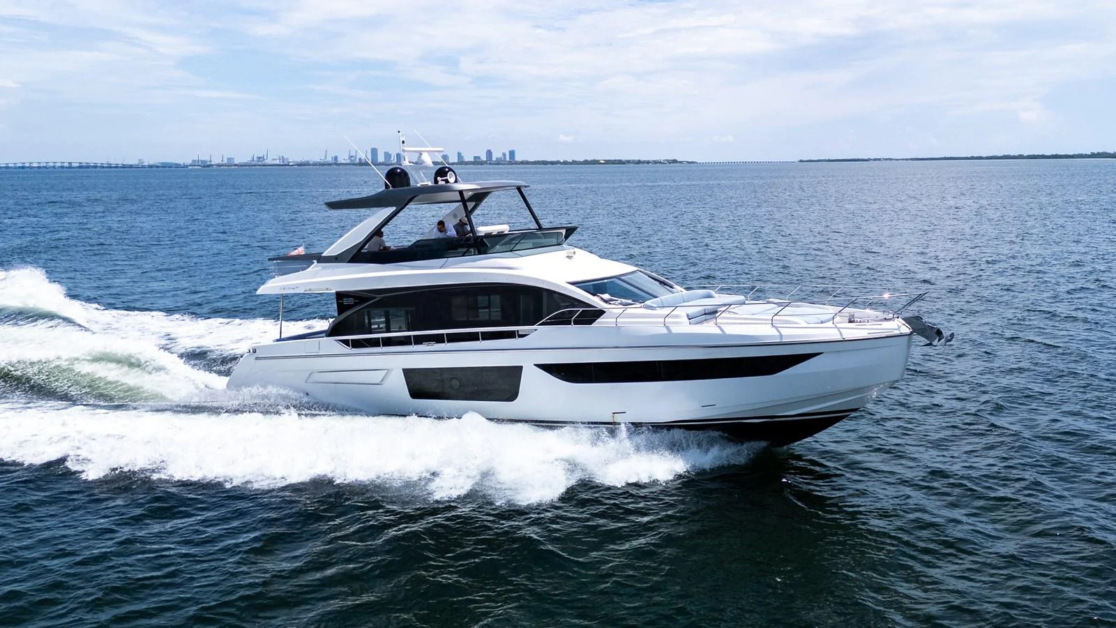 A sleek and modern yacht cruises swiftly on open waters under a clear sky. aboard GONE PHISHING Yacht for Sale