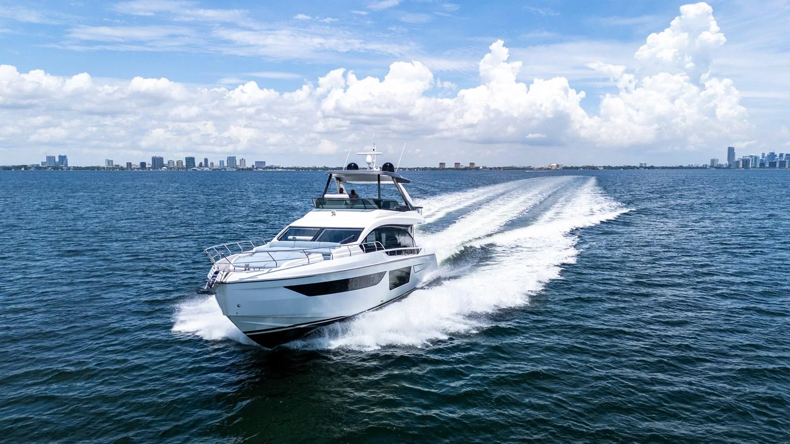 A sleek yacht cruises swiftly across the open water under a bright blue sky. aboard GONE PHISHING Yacht for Sale
