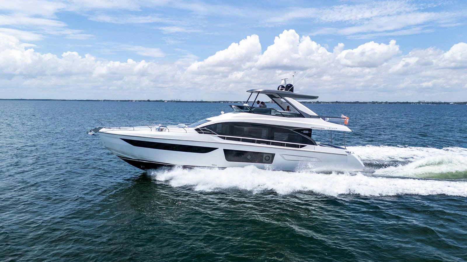 A sleek and modern yacht glides effortlessly across the open water under a bright blue sky. aboard GONE PHISHING Yacht for Sale