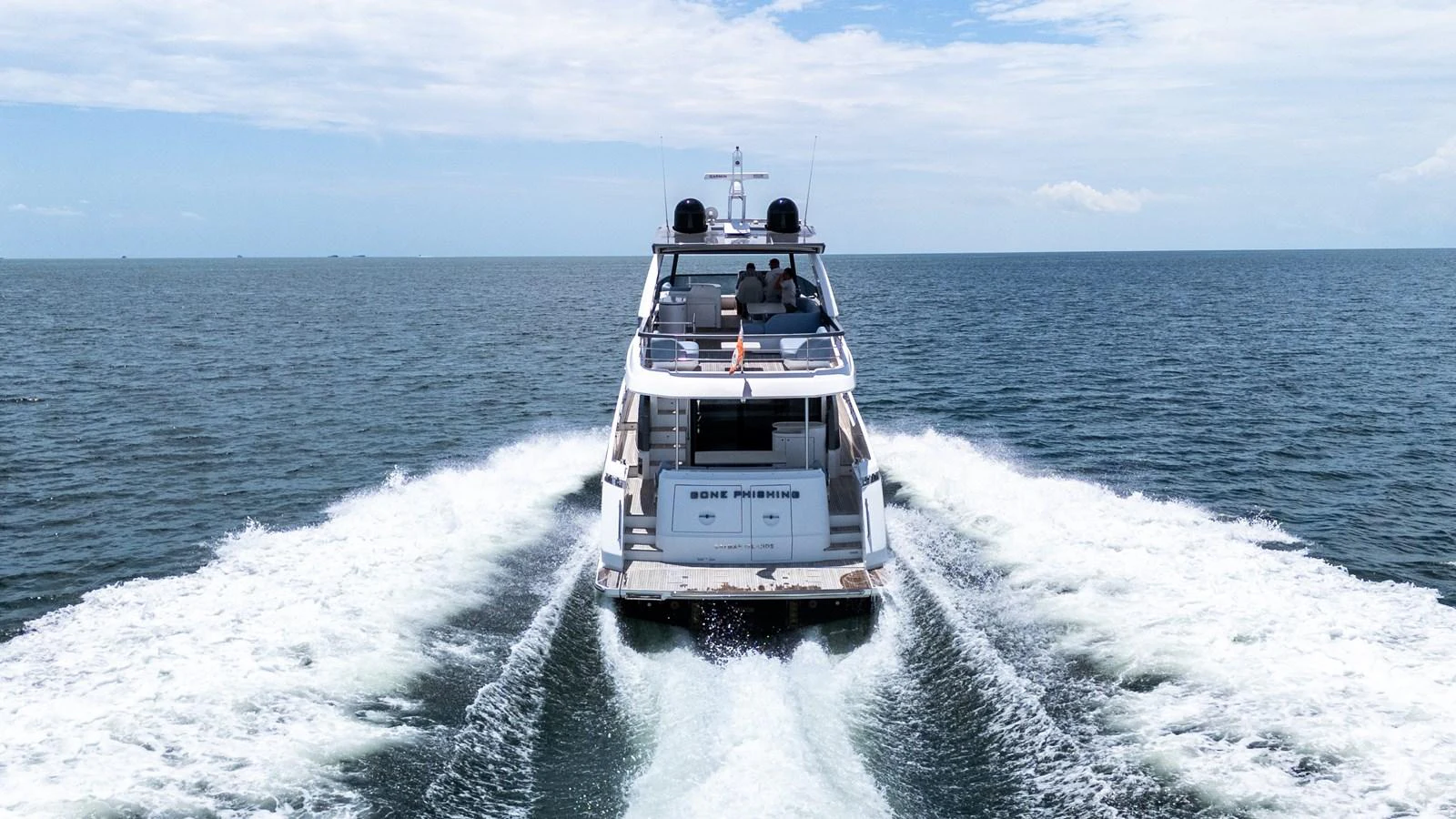 The yacht cruises smoothly through open waters, leaving a trail of white wake behind. aboard GONE PHISHING Yacht for Sale
