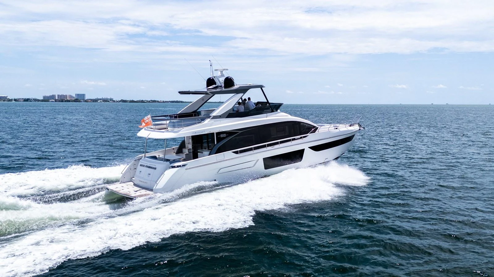 A sleek yacht cruises swiftly across the open water under a clear sky. aboard GONE PHISHING Yacht for Sale