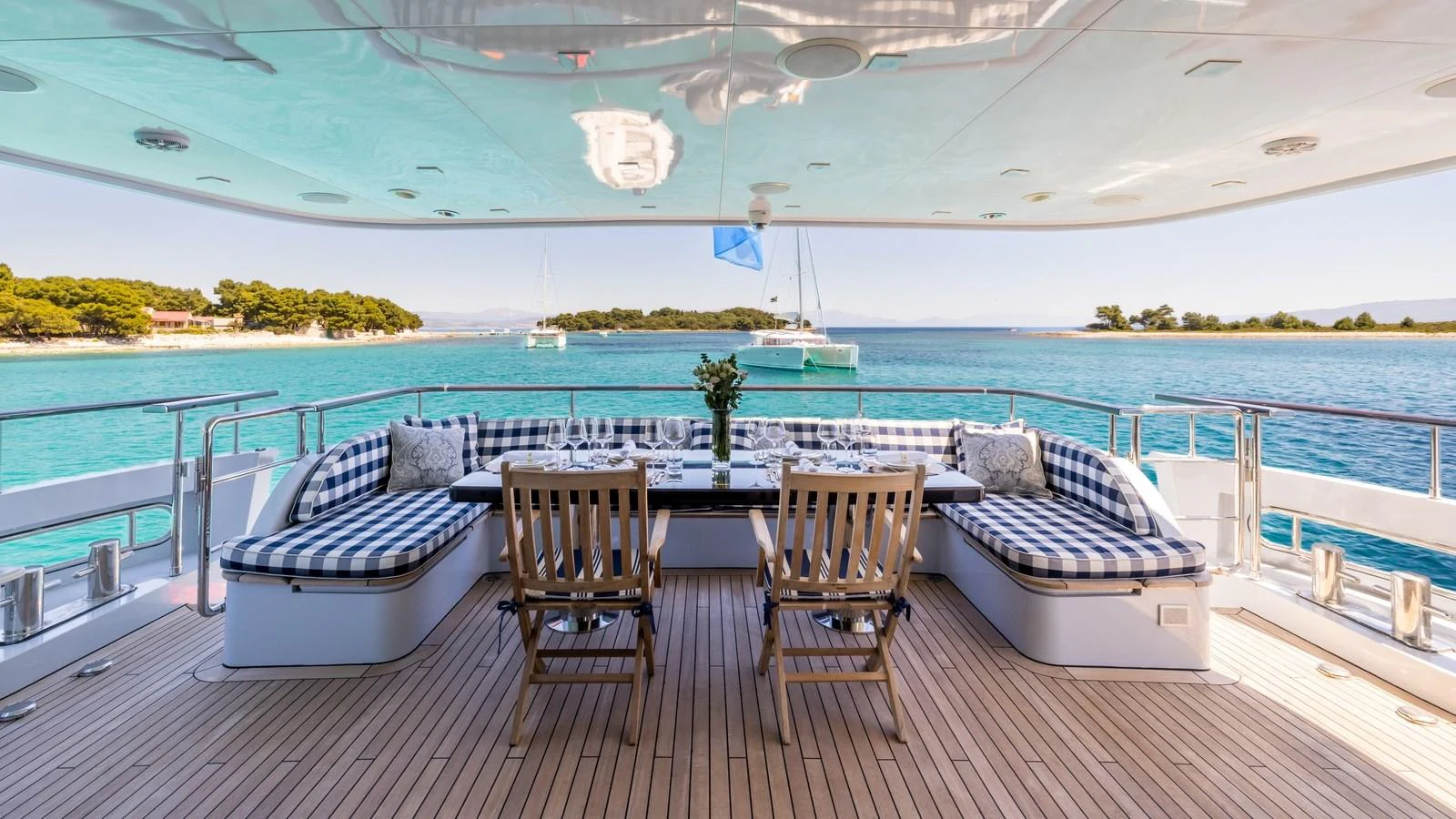 The aft deck features a spacious seating area with a dining table, offering stunning views of the surrounding waters. aboard LA STELLA DEI MARI Yacht for Sale