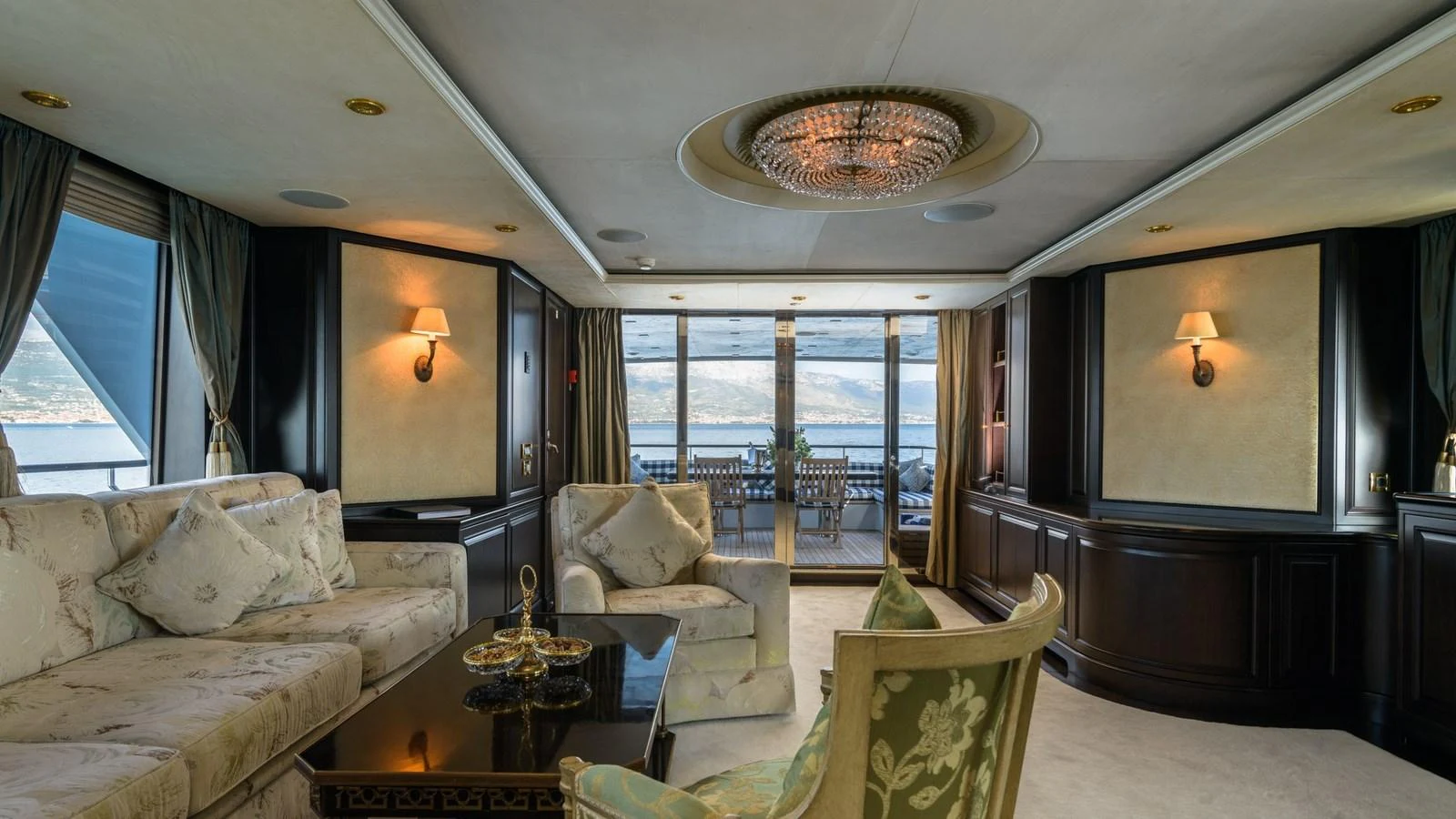 The yacht's salon features elegant furnishings and a stunning view through large windows. aboard LA STELLA DEI MARI Yacht for Sale