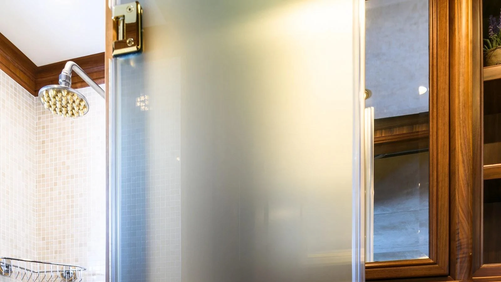 The yacht's bathroom features a frosted glass shower door and elegant wooden accents. aboard LA STELLA DEI MARI Yacht for Sale