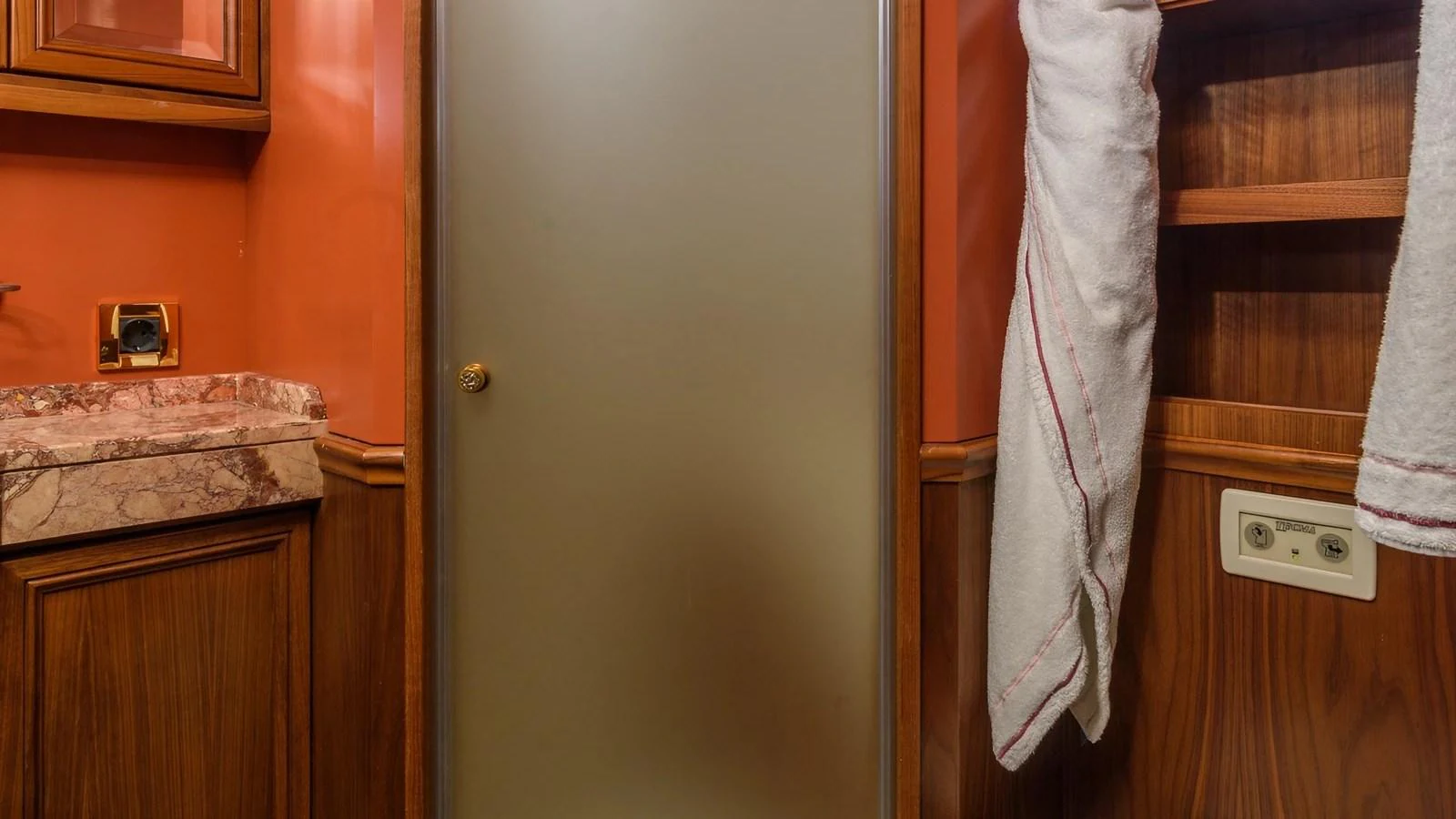 The image showcases a yacht's interior with a frosted glass door and wooden cabinetry. aboard LA STELLA DEI MARI Yacht for Sale