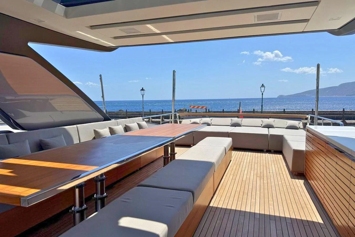 The aft deck offers a spacious and inviting area with ample seating and a large dining table, perfect for alfresco dining and relaxation. aboard CUT Yacht for Sale