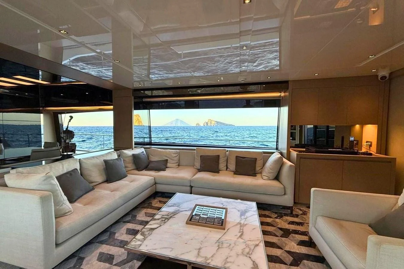 The salon features a spacious seating area with a stunning ocean view through large windows. aboard CUT Yacht for Sale