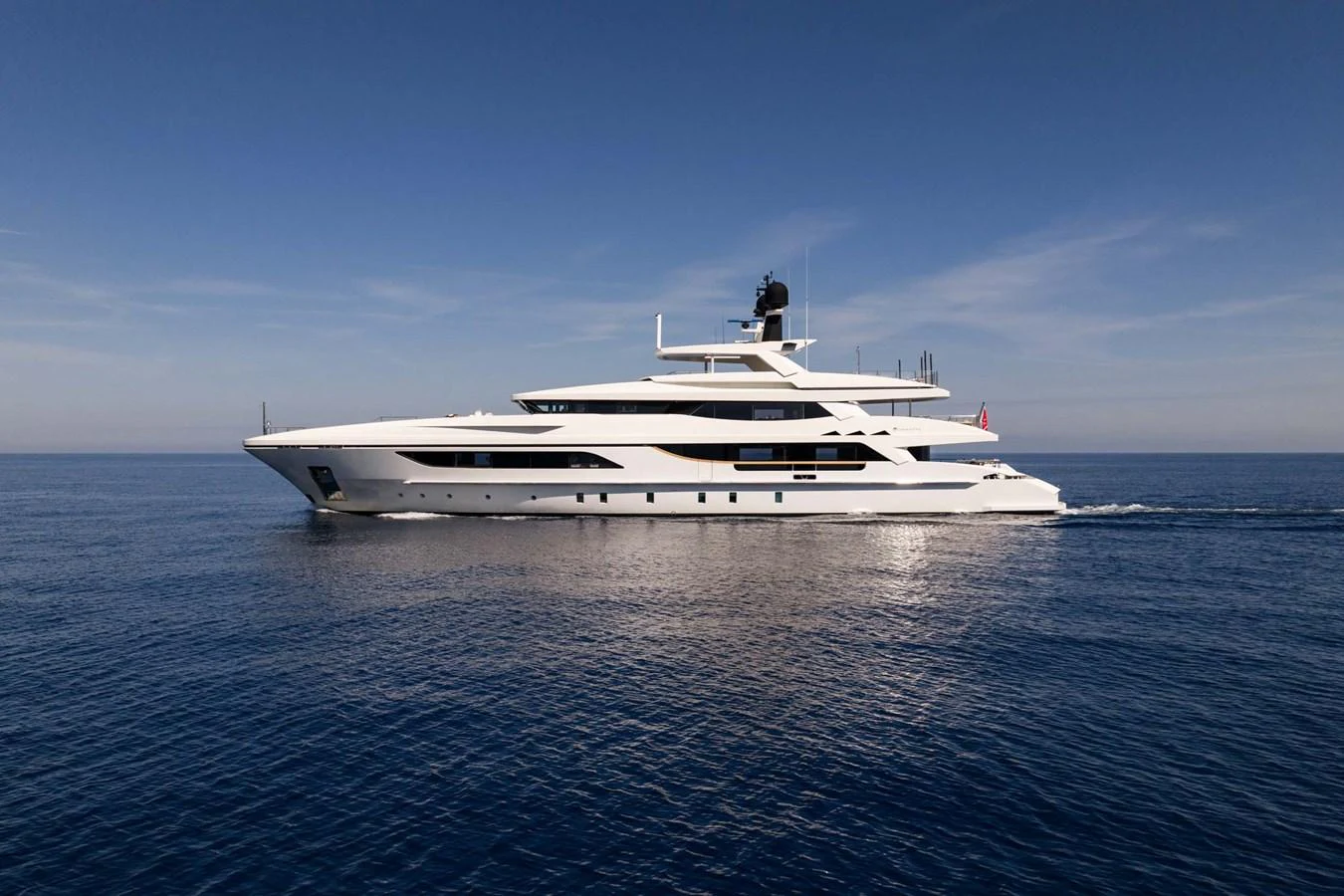 A sleek and modern yacht glides gracefully across calm waters under a clear blue sky. aboard MR. T Yacht for Sale