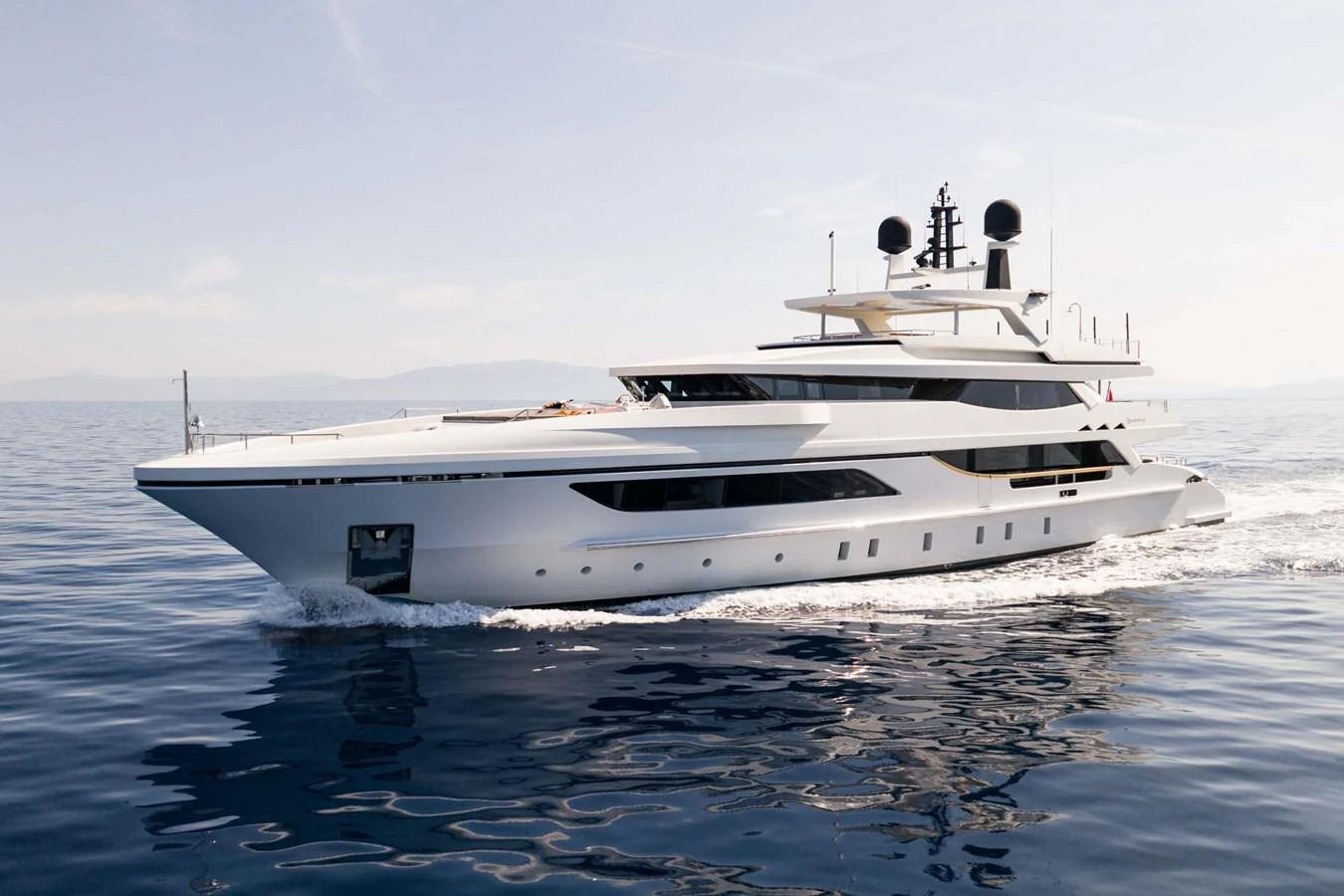 A sleek and modern yacht cruises smoothly on calm waters under a clear sky. aboard MR. T Yacht for Sale