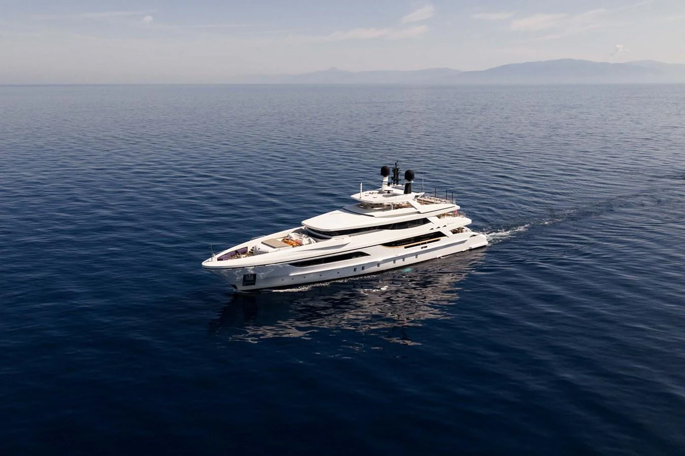 A sleek and modern yacht cruises gracefully on calm waters under a clear sky. aboard MR. T Yacht for Sale