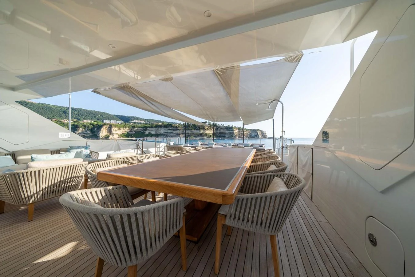 The aft deck features a spacious dining area with a large table and comfortable seating, perfect for alfresco meals. aboard MR. T Yacht for Sale