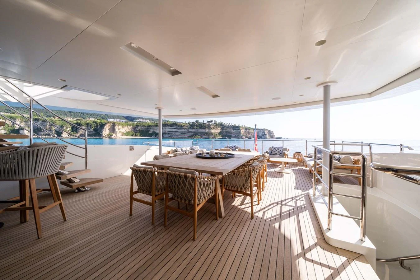 The aft deck offers a spacious and elegant outdoor dining area with stunning views of the surrounding waters. aboard MR. T Yacht for Sale