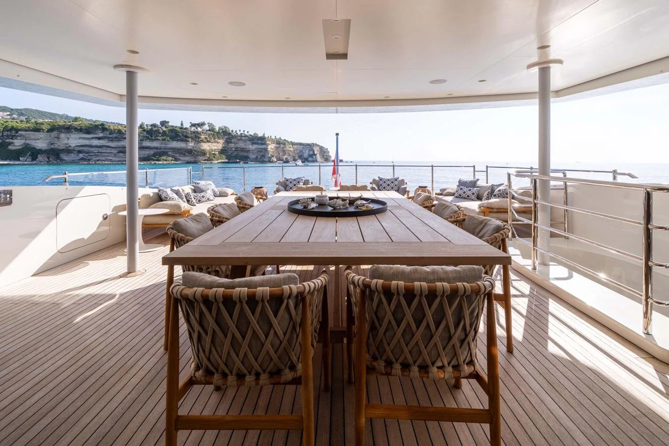 The aft deck features a spacious dining area with a stunning ocean view. aboard MR. T Yacht for Sale