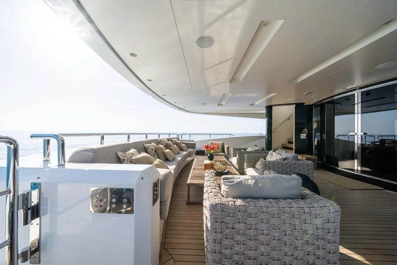 The aft deck features a spacious and comfortable seating area with elegant wicker furniture and plush cushions. aboard MR. T Yacht for Sale
