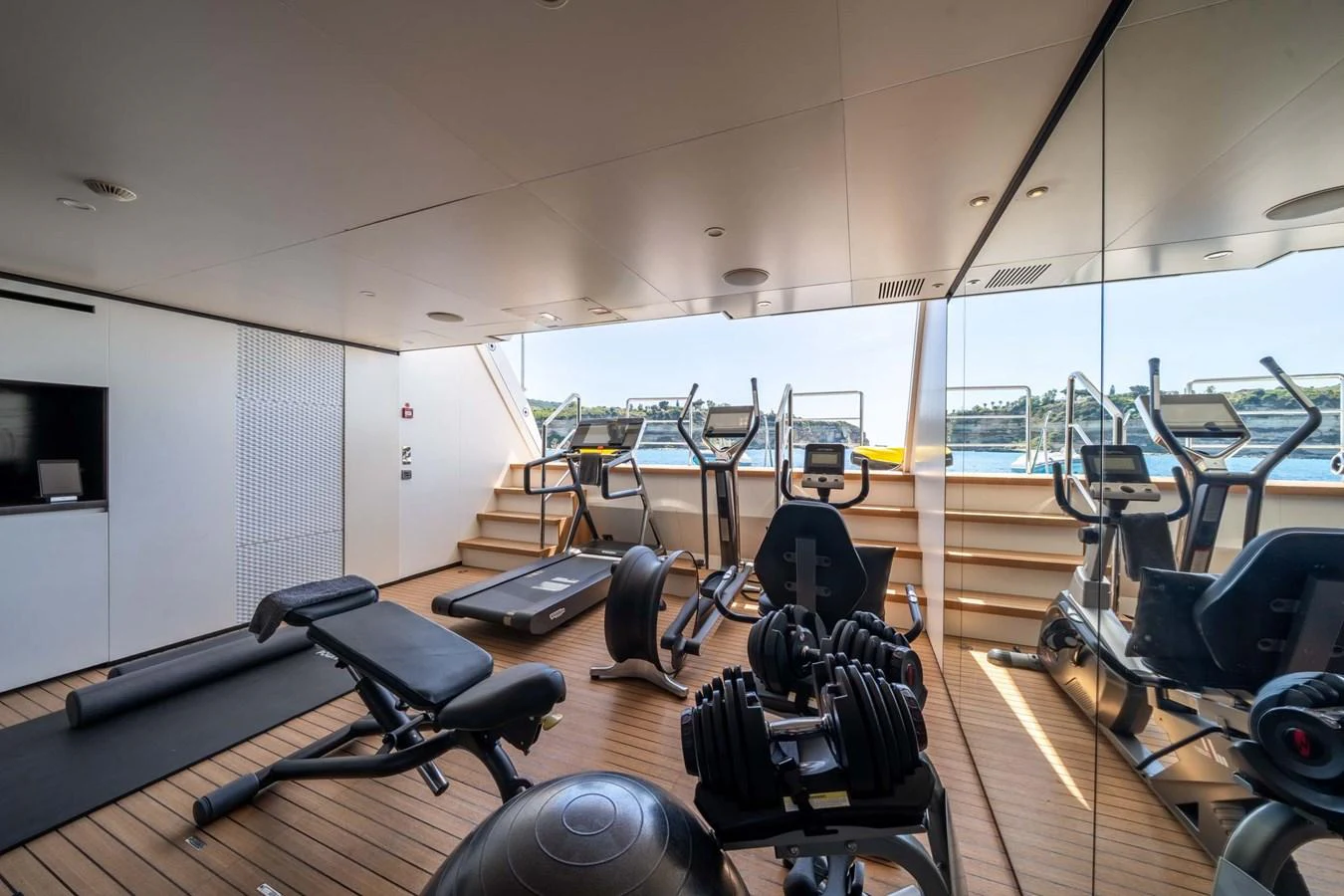 The yacht features a well-equipped gym with a stunning view of the water. aboard MR. T Yacht for Sale