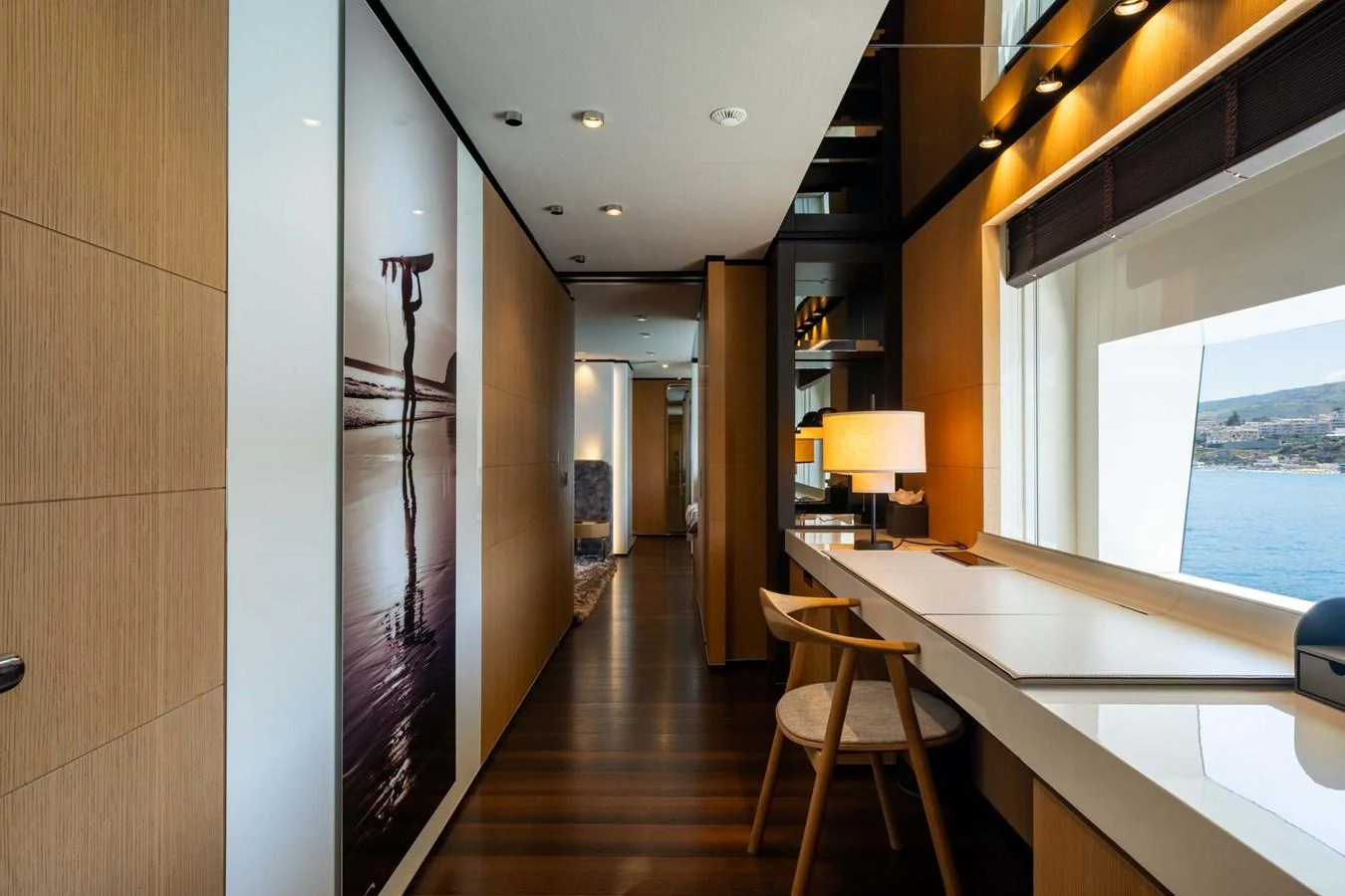 A modern and elegant hallway with a desk area and large windows offering scenic views. aboard MR. T Yacht for Sale