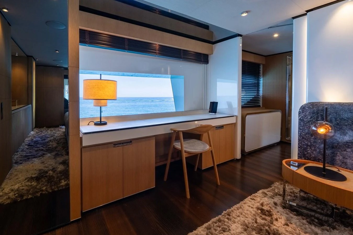 A stylish interior space featuring a desk area with a view of the sea. aboard MR. T Yacht for Sale