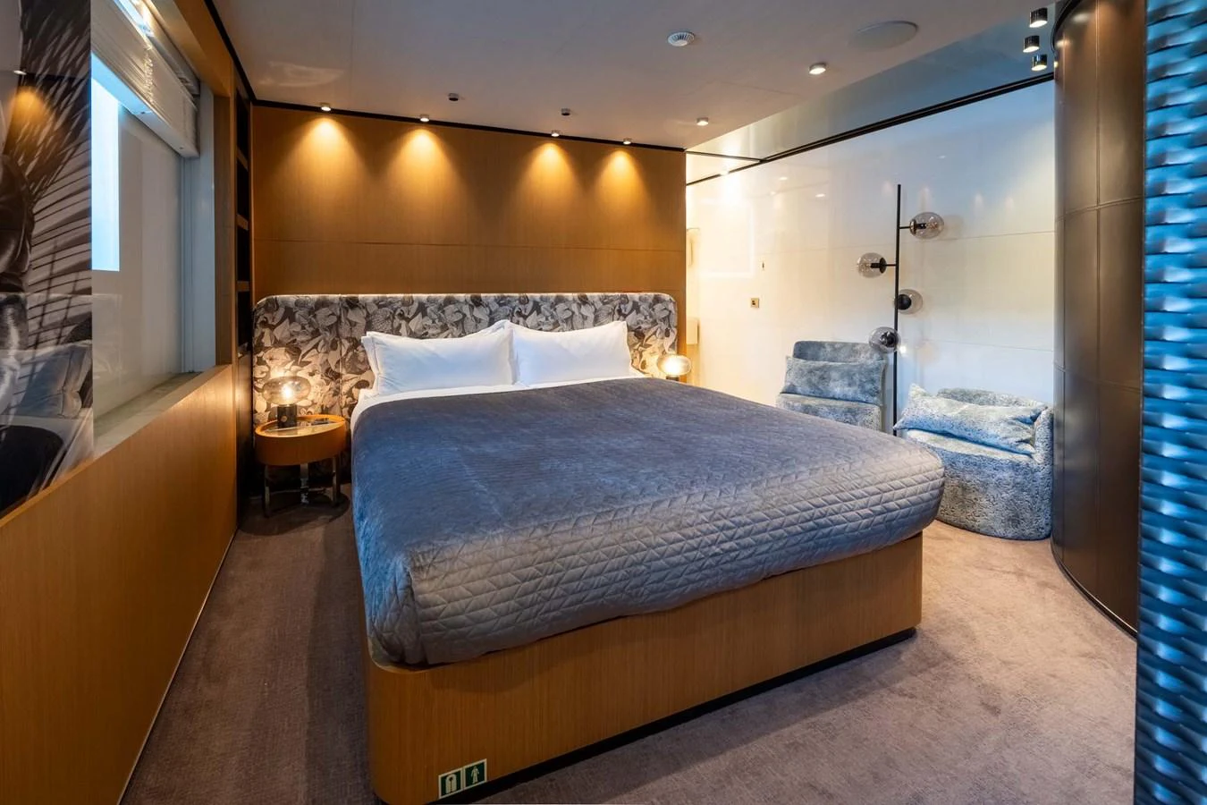 The master stateroom features a spacious bed with elegant lighting and modern decor. aboard MR. T Yacht for Sale