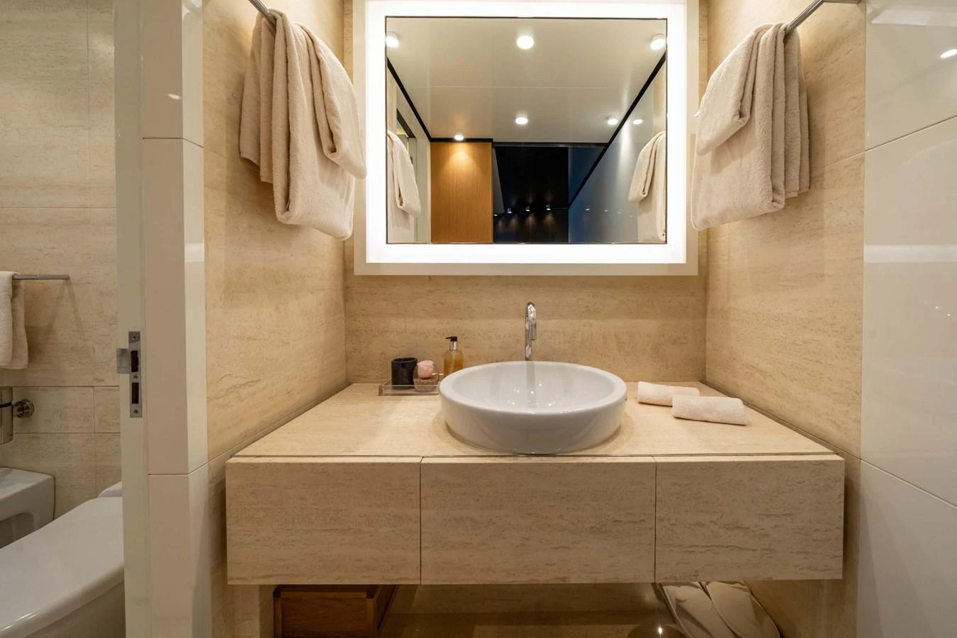 The yacht's bathroom features a sleek, modern design with a well-lit vanity area and elegant fixtures. aboard MR. T Yacht for Sale