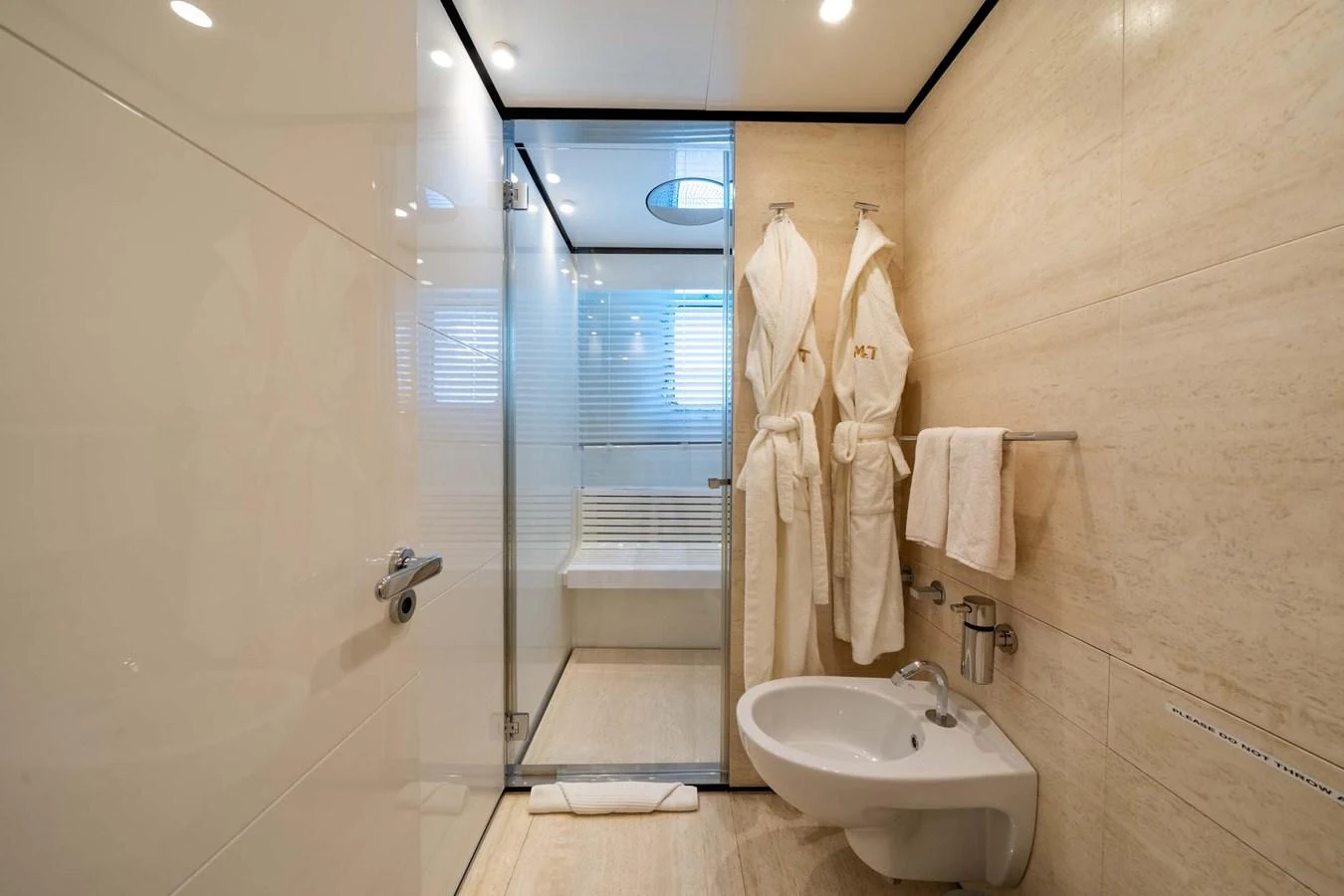 The yacht's bathroom features a modern design with luxurious amenities and a spacious shower area. aboard MR. T Yacht for Sale