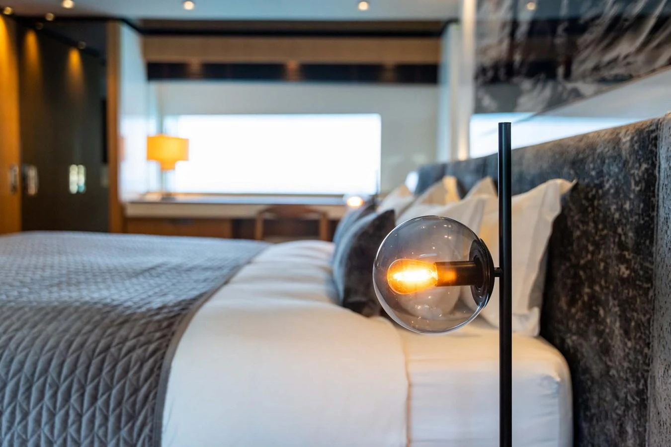 A luxurious stateroom featuring a plush bed and modern lighting. aboard MR. T Yacht for Sale