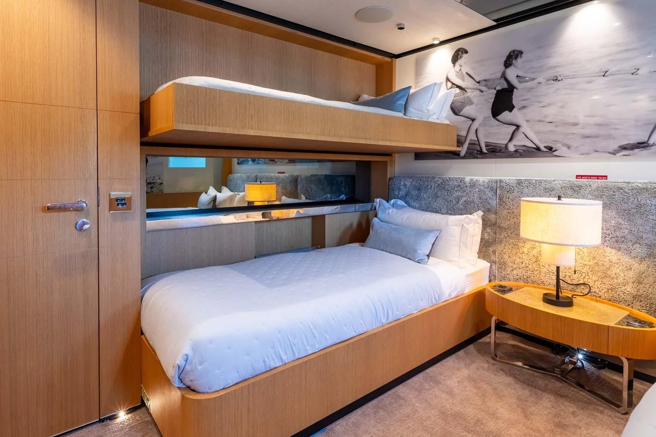 The guest stateroom features cozy twin bunk beds with modern decor and warm lighting. aboard MR. T Yacht for Sale