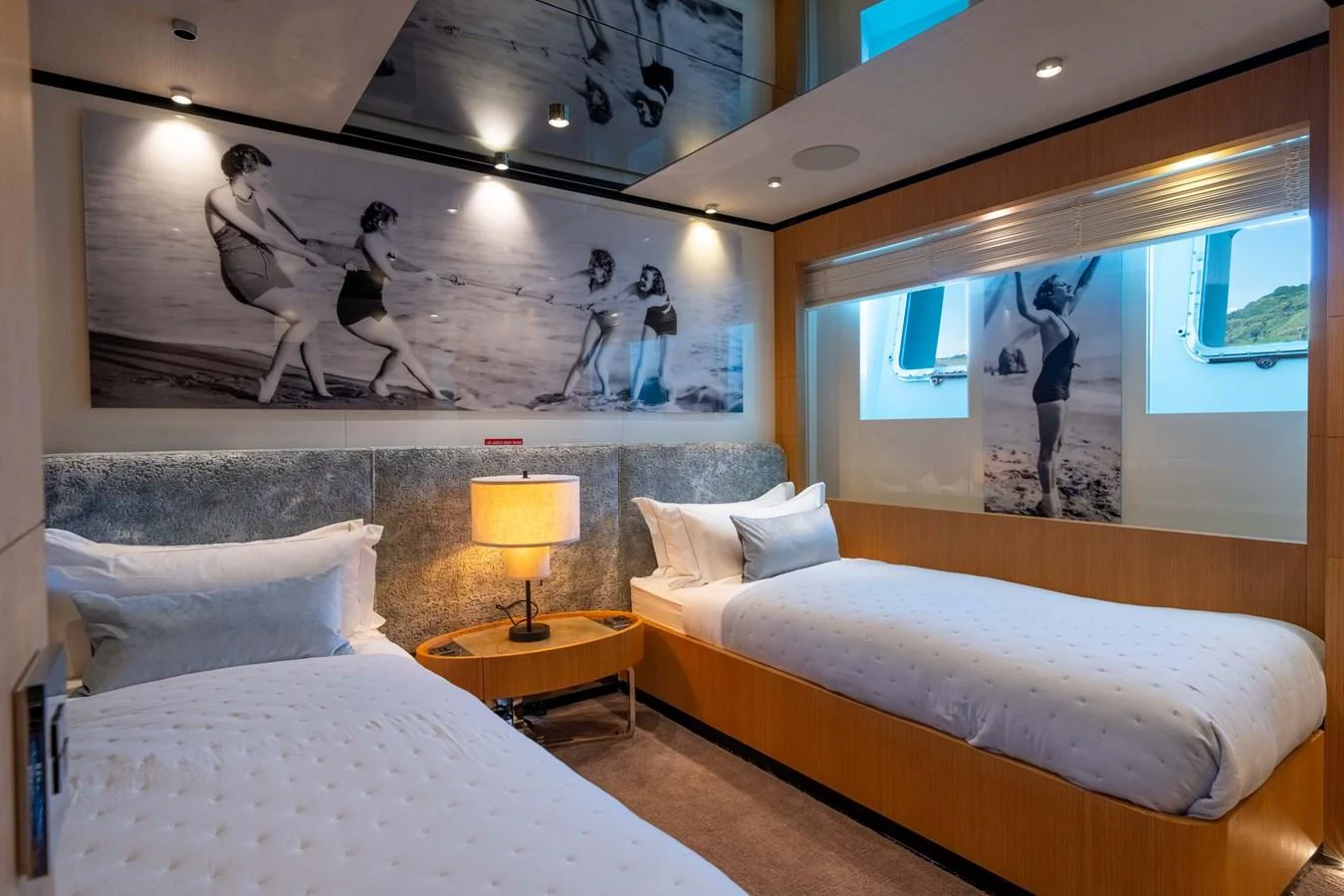 The guest stateroom features twin beds and stylish decor with artistic wall photos. aboard MR. T Yacht for Sale