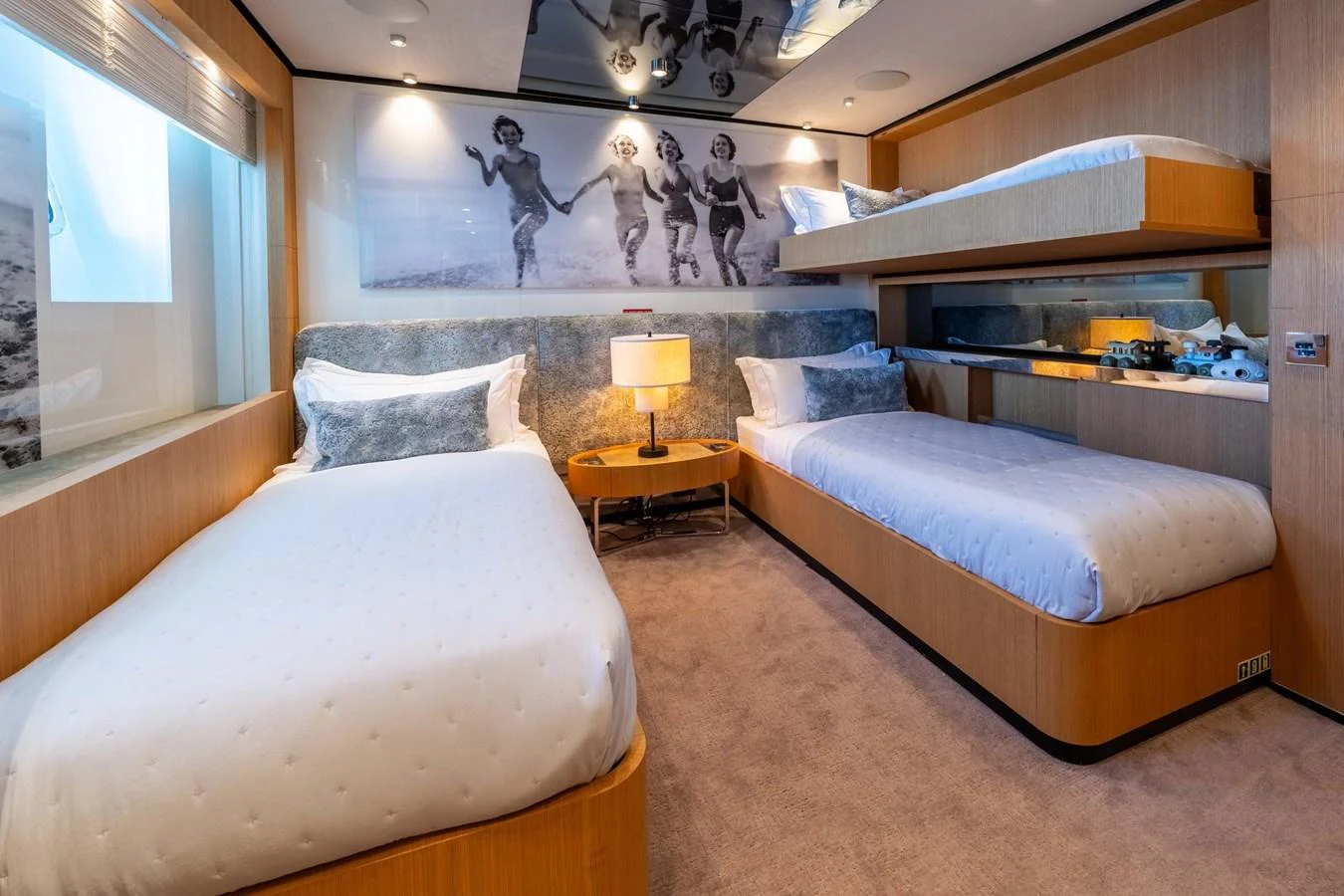 The guest stateroom features cozy twin beds and a bunk, with a warm and inviting decor. aboard MR. T Yacht for Sale