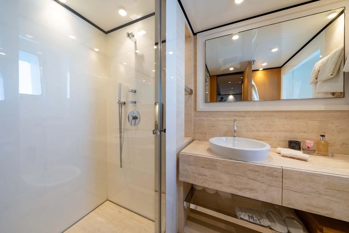 A modern yacht bathroom featuring a spacious shower and elegant vanity. aboard MR. T Yacht for Sale
