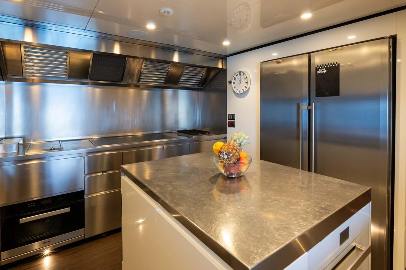 The yacht's galley features sleek stainless steel appliances and a spacious island counter. aboard MR. T Yacht for Sale