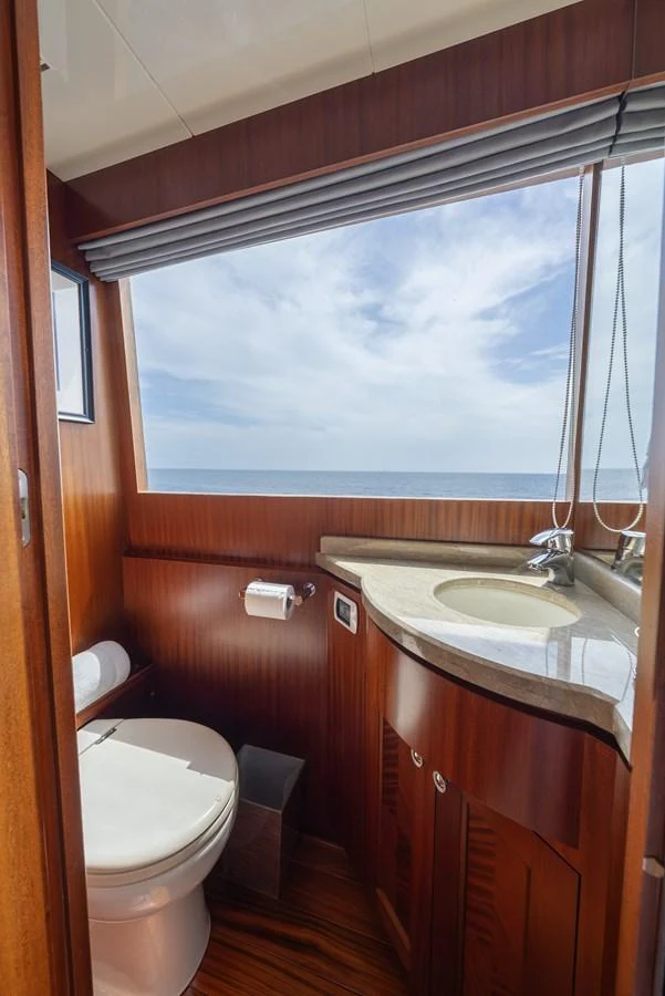 A well-appointed yacht bathroom with a large window offering a stunning sea view. aboard ABOAT TIME Yacht for Sale