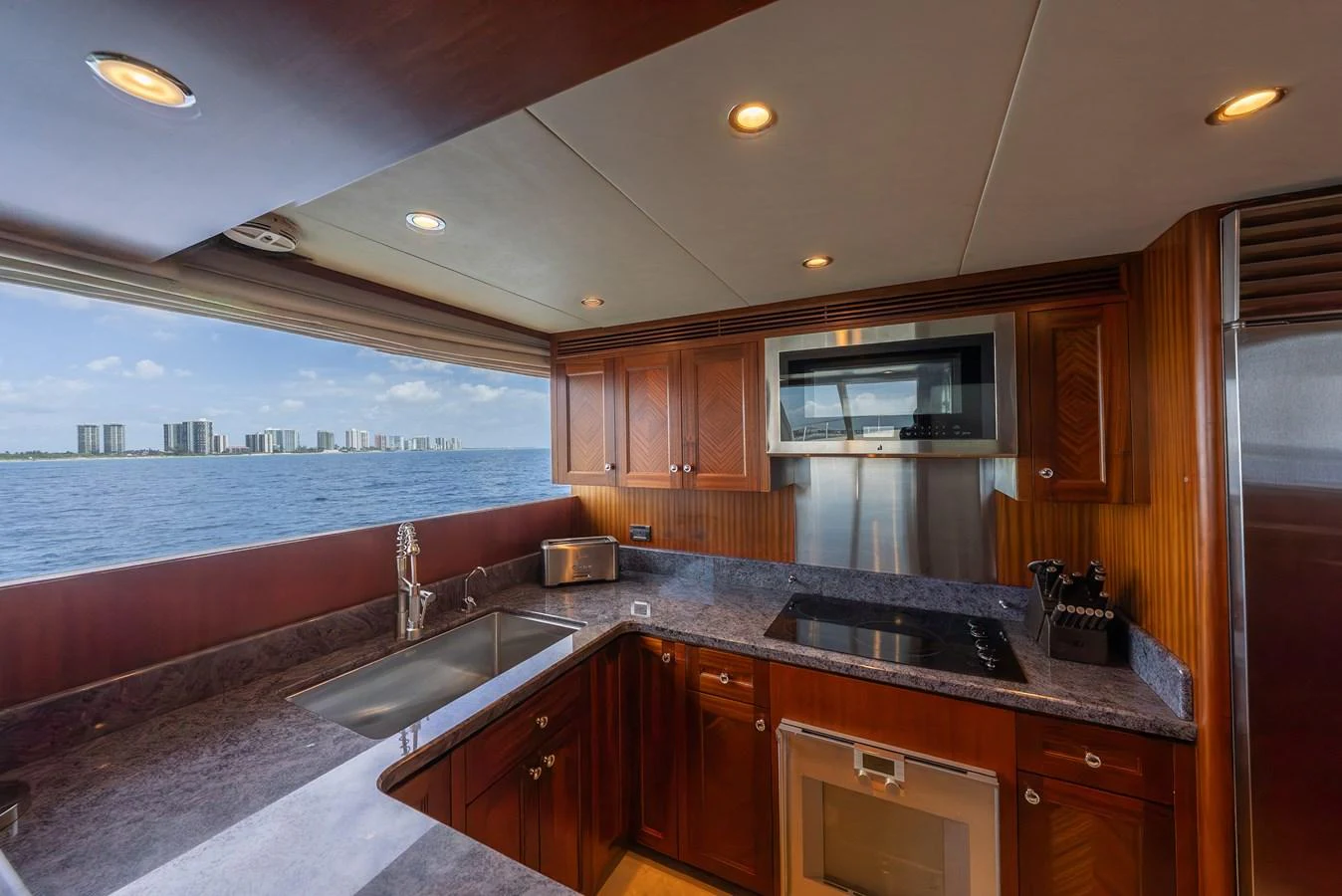 The galley offers a stunning view of the sea, complemented by modern appliances and rich wood finishes. aboard ABOAT TIME Yacht for Sale