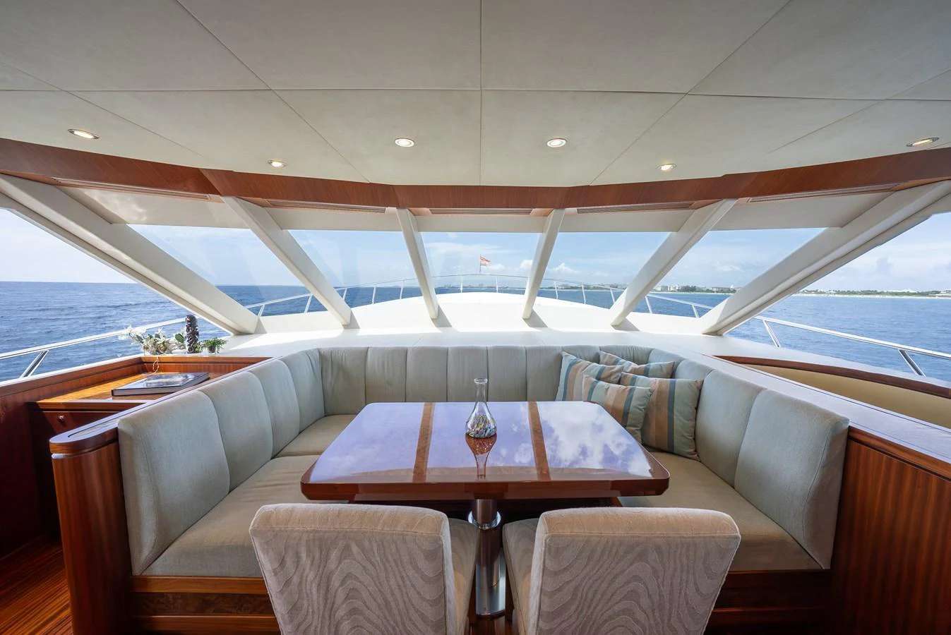 The salon offers a panoramic view with plush seating and a polished wooden table, perfect for relaxation and socializing. aboard ABOAT TIME Yacht for Sale