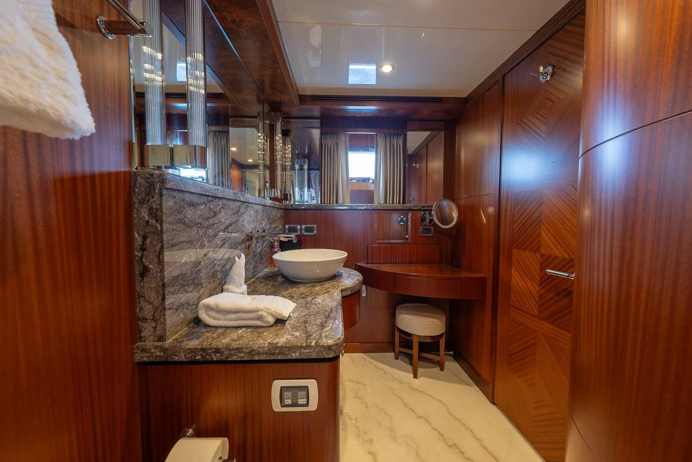 The yacht's bathroom features luxurious wood paneling and a sleek marble countertop. aboard ABOAT TIME Yacht for Sale