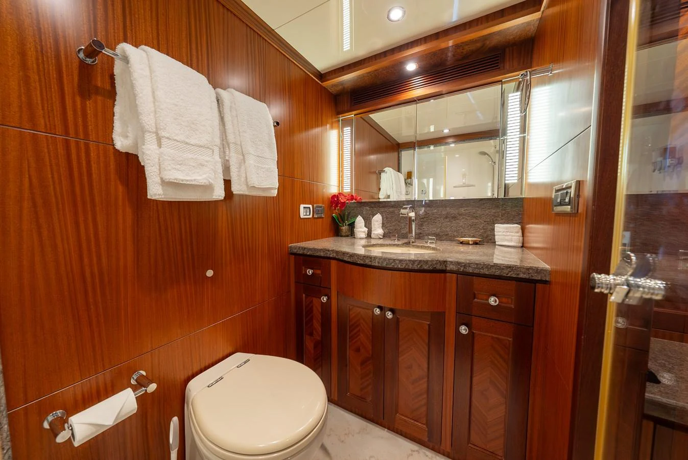 The yacht's bathroom features elegant wood paneling, a granite countertop, and luxurious amenities. aboard ABOAT TIME Yacht for Sale