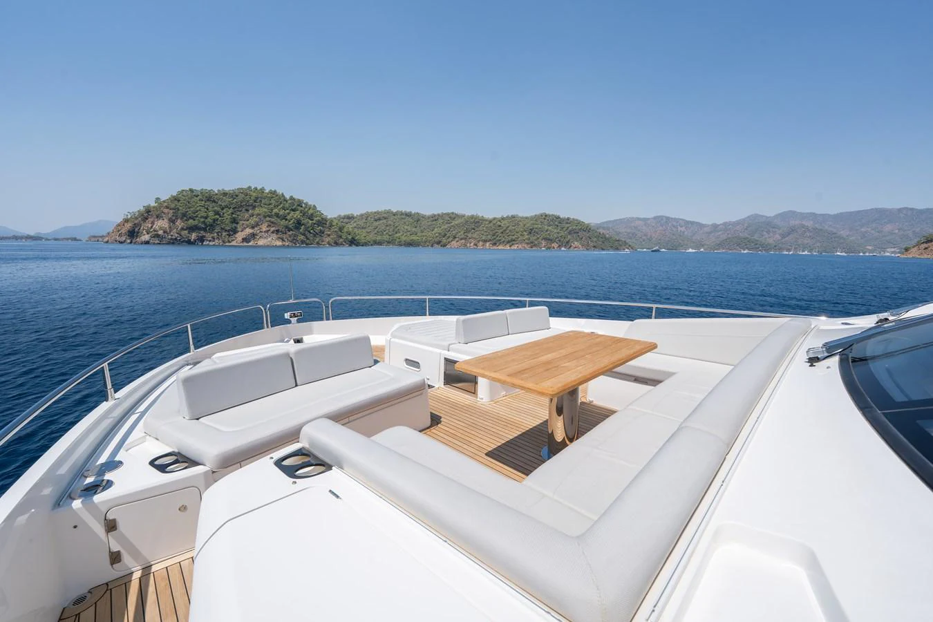 The foredeck offers a spacious seating area with a wooden table, perfect for enjoying the scenic views. aboard NAAMA Yacht for Sale