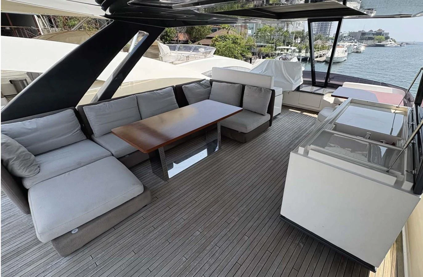 The aft deck features a spacious seating area with plush cushions and a sleek wooden table, perfect for outdoor relaxation and dining. aboard ABIGAIL Yacht for Sale