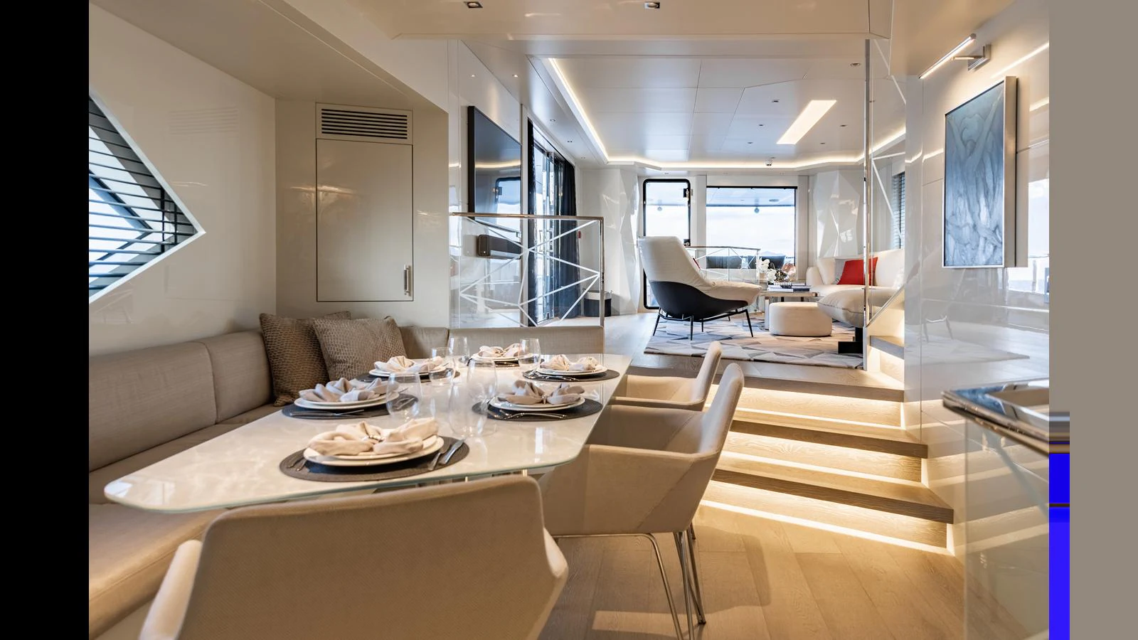 The yacht's salon features a modern dining area and a comfortable lounge with elegant decor. aboard HULL #5 Yacht for Sale