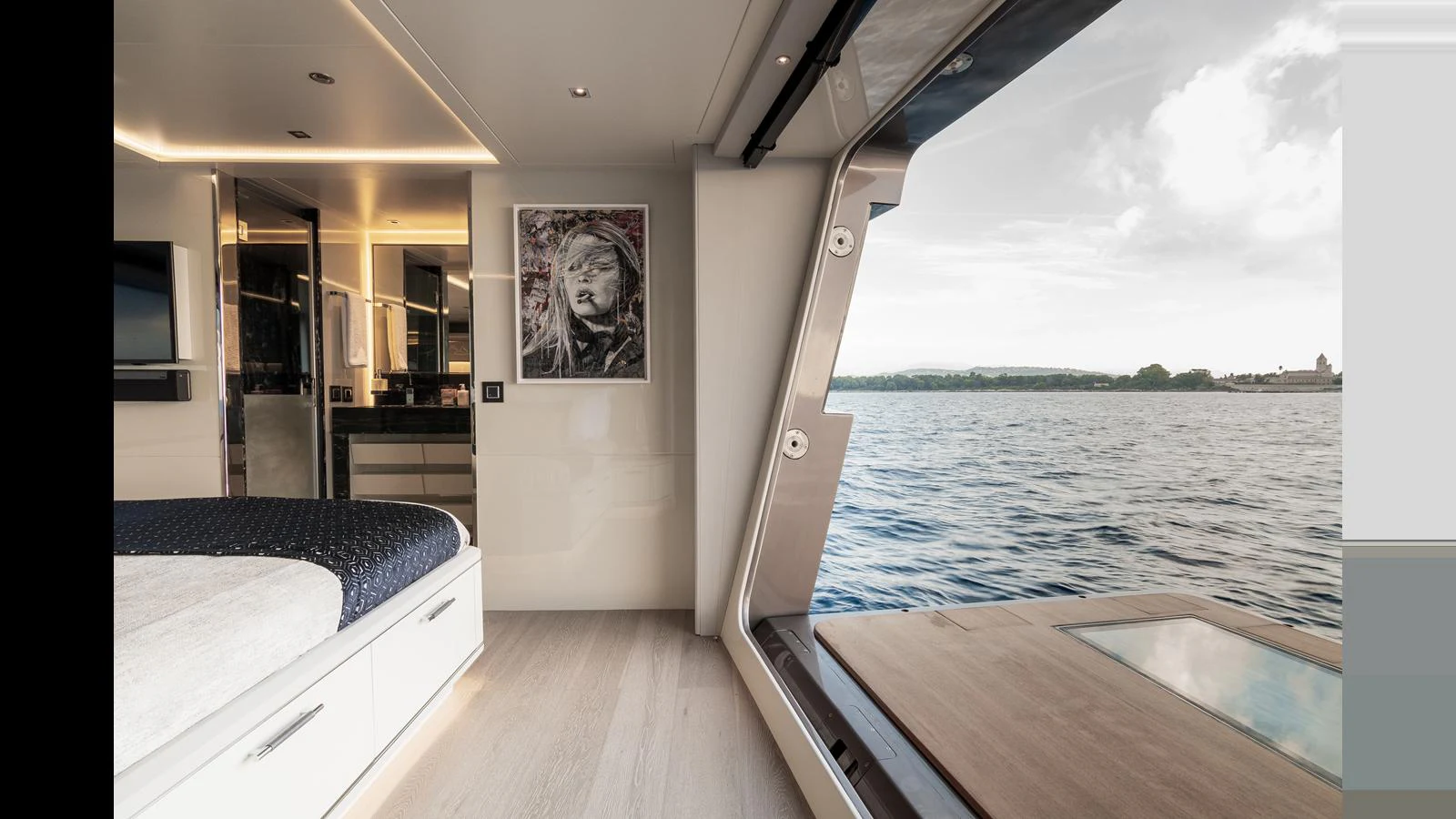 A luxurious stateroom with a large window offering a stunning view of the water. aboard HULL #5 Yacht for Sale