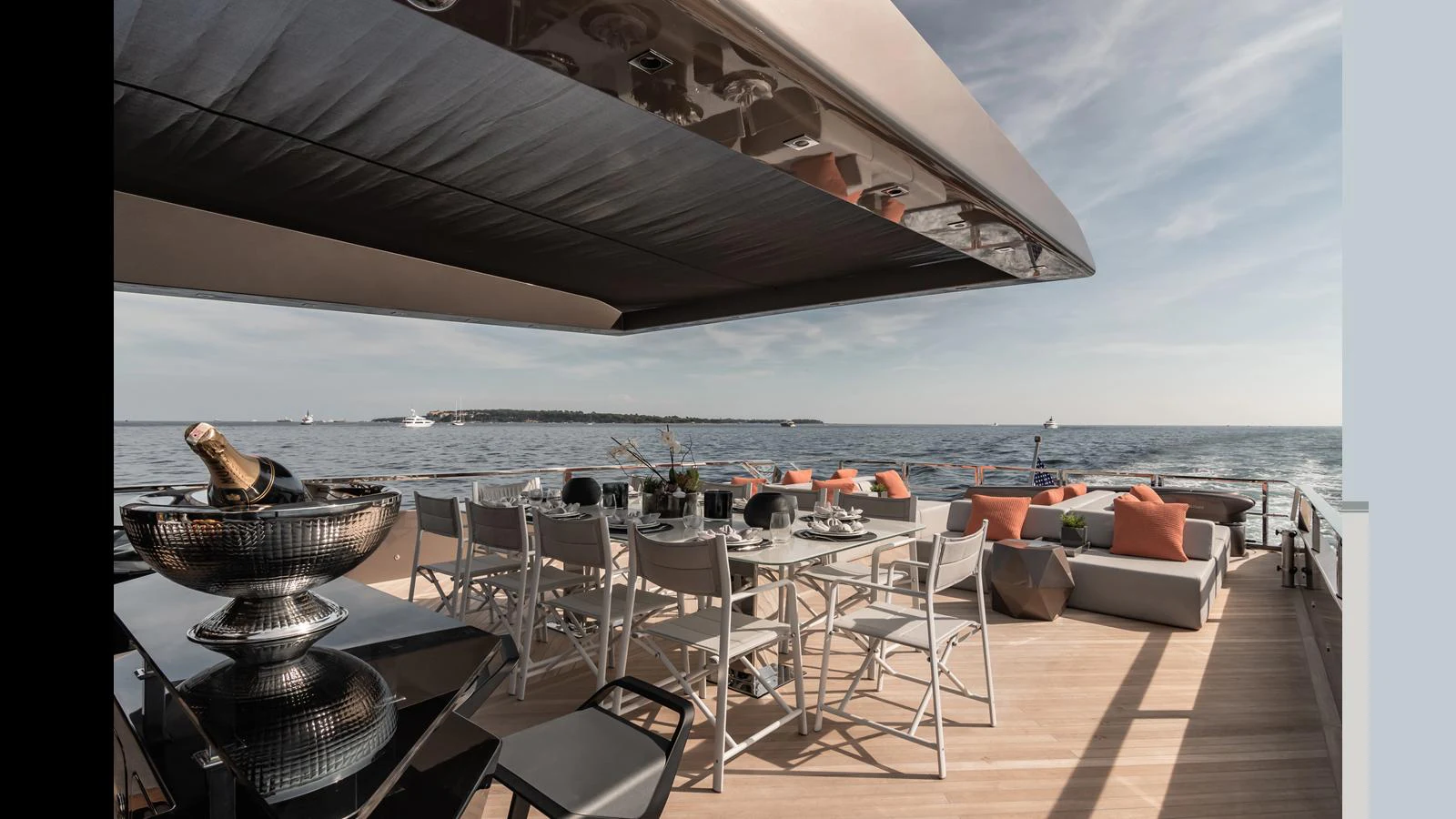 The aft deck features a stylish dining area with a stunning ocean view. aboard HULL #5 Yacht for Sale
